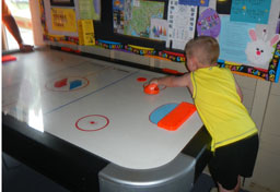 Father and son play air hockey in our rec room